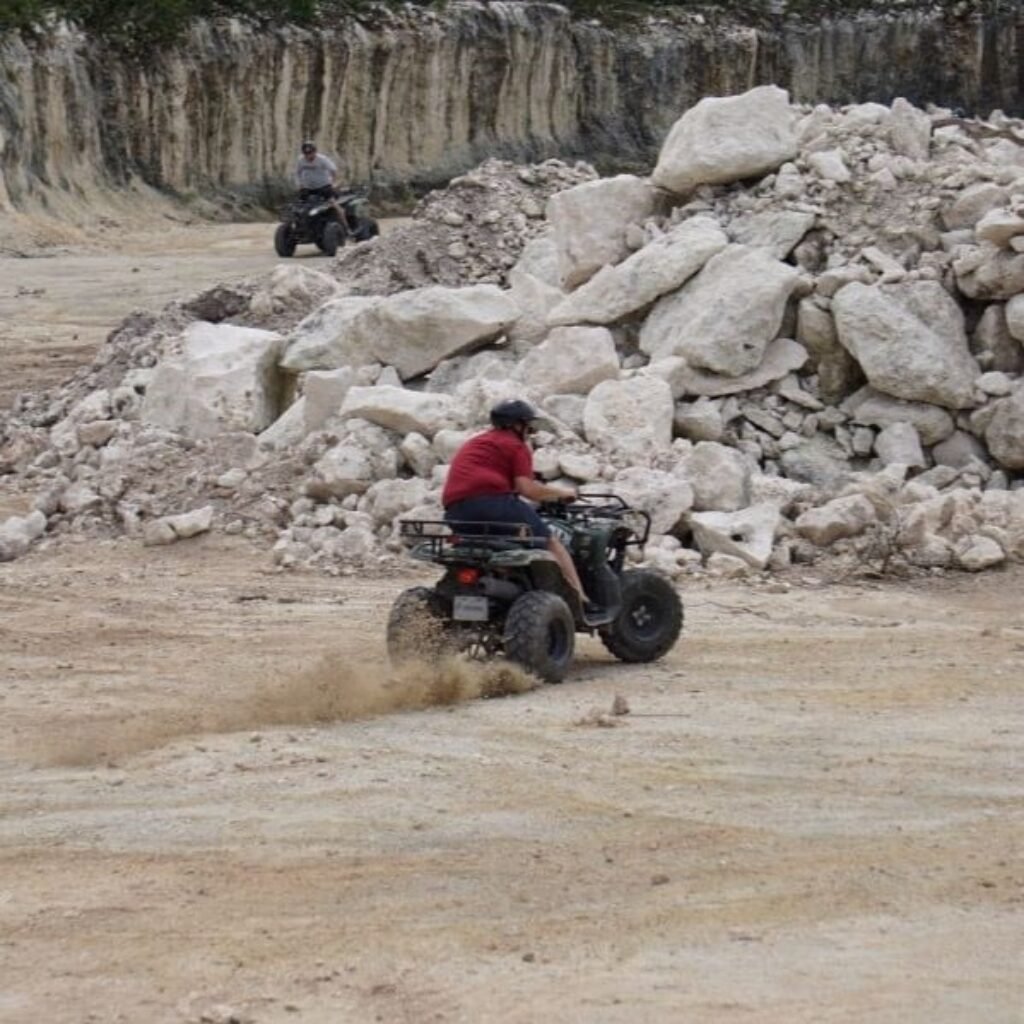 a man riding a atv kicking up dust