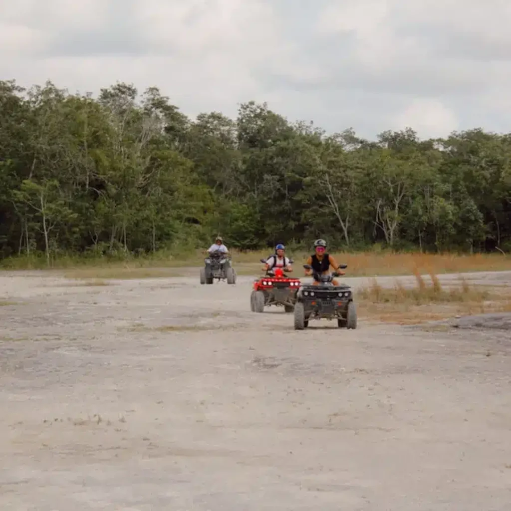 3 atvs in a rock quarry driving