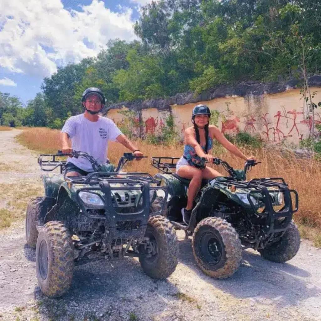 a man and woman on a pair atv's in cozumel