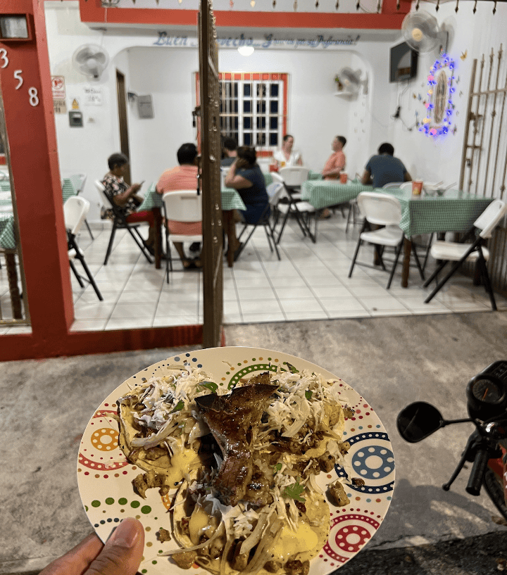 A plate of food being held in Front of a local fppd.place in cozumel