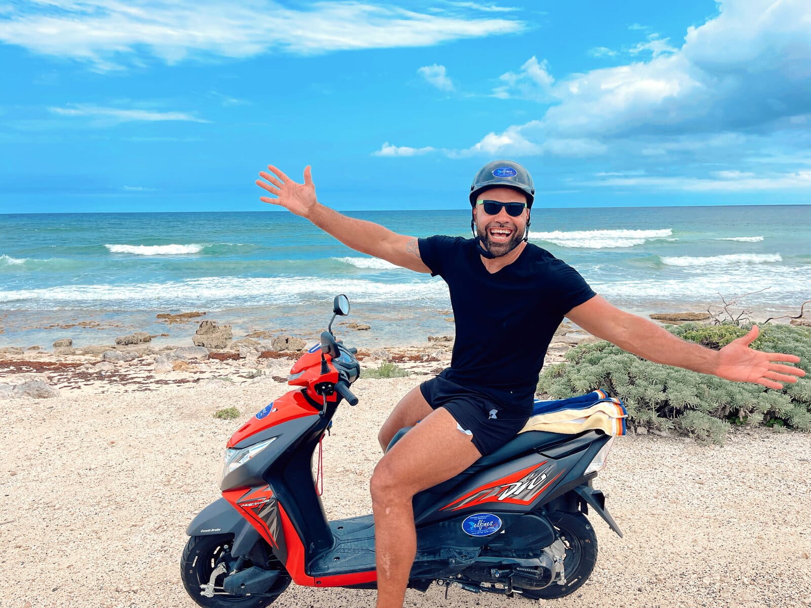 The author on a scooter in front of the ocean demonstrating is Cozumel Mexico safe