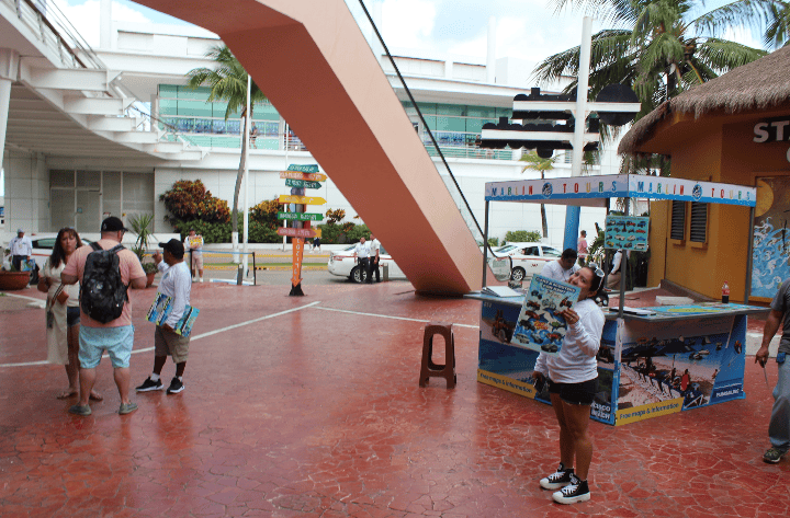 A photo of Cozumel cruise port punta Langosta and a tour salesperson holding a sign