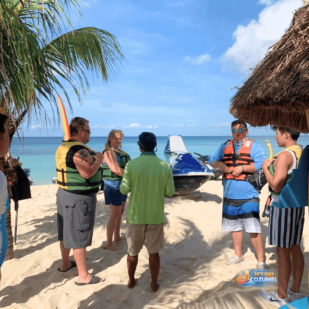 A family of five listening to a instructor explain a Cozumel jet ski rental rules