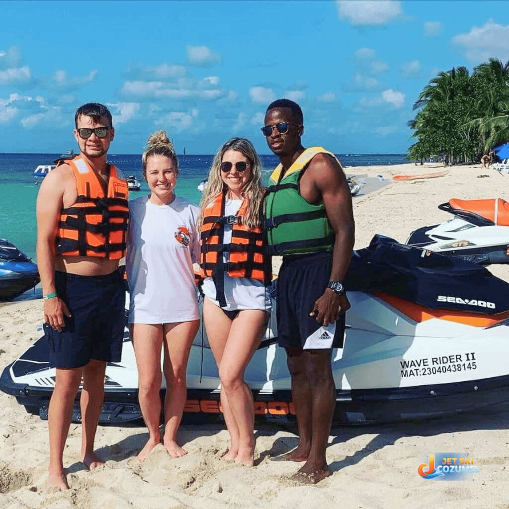 Two couples posing for a jet ski rental Cozumel offers to travelers with the beach on the background