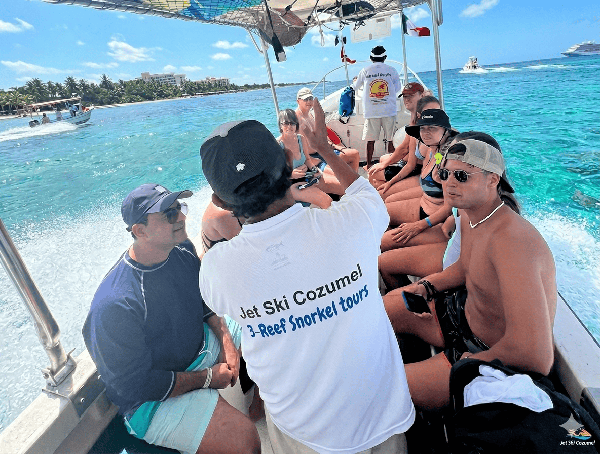 el-cielo-cozunel-snorkeling- – Jet Ski Cozumel Group of tourists on a speedboat, wearing swimsuits, listening to a guide in a white shirt with a snorkeling tour logo amid bright turquoise Caribbean water.
